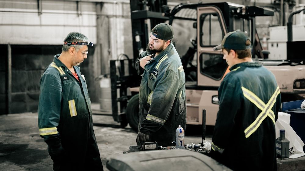 Mach 6 staff discussing fleet maintenance planning on the shop floor