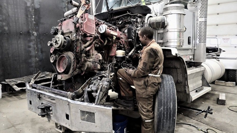Mach 6 technician working on a pulled diesel engine during an out-of-frame rebuild